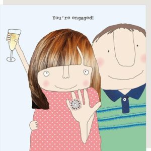 Engaged card. Couple with the girl showing off a large diamond ring on her wedding finger. Caption: You're engaged.