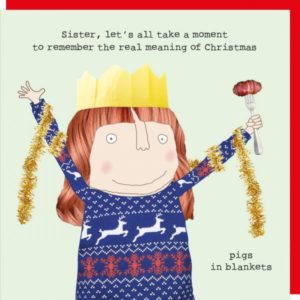 Sister Pigs Christmas card featuring a lady wearing a Christmas jumper and tinsel and holding a pigs in blankets on a fork. Caption: 'Sister, let's all take a moment to remember the real meaning of Christmas. Pigs in blankets.'