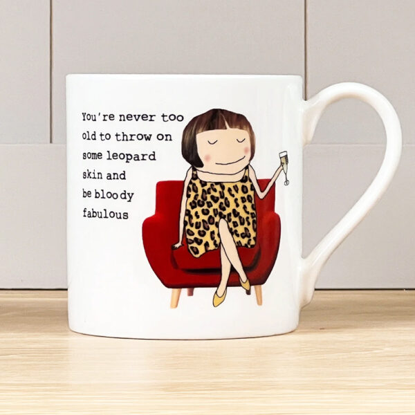 white mug with an image of a woman dressed in leopard print on a chair - caption reads 'you're never too old to throw on some leopard skin and be bloody fabulous.'